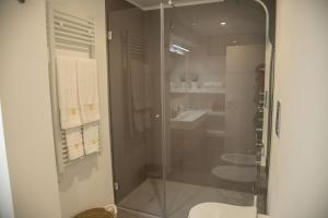 a glass shower in a bathroom with a sink at Casa Sant'Orsola - Appartamento nella città antica in Molfetta +24 photos