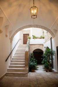 a hallway with stairs and a chandelier at Casa Sant'Orsola - Appartamento nella città antica in Molfetta