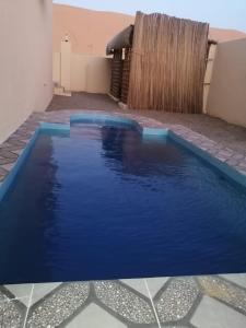 duży błękitny basen na dziedzińcu w obiekcie شاليهات رمال بديه w mieście Al Raka