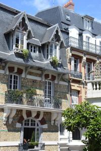 um grande edifício de tijolos com janelas e varandas em La Chambre du 21 em Trouville-sur-Mer