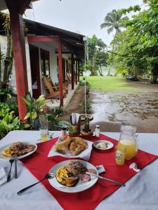 a table with plates of food and drinks on it at Cabañas Daneysha in Tortuguero