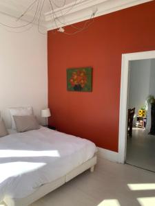 エペルネーにあるLe Saint-Rémyの赤い壁のベッドルーム1室、ベッド1台が備わります。