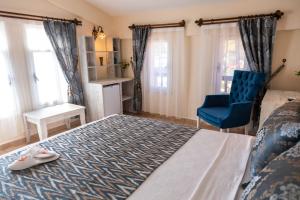 a bedroom with a bed and a blue chair at Portakal Hotel Dalyan in Dalyan