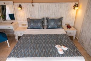 a bedroom with a bed with two shoes on it at Portakal Hotel Dalyan in Dalyan