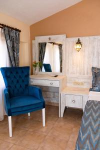 a bedroom with a blue chair and a desk and a mirror at Portakal Hotel Dalyan in Dalyan +29 photos