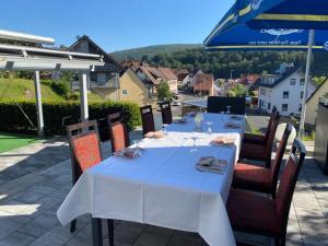 einen Tisch mit einem weißen Tischtuch auf einer Terrasse in der Unterkunft Hotel Cafe Gästehaus Stefanie in Partenstein