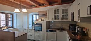 a large kitchen with white cabinets and a sink at Die Hube in Leutschach