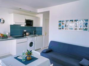 salon z niebieską kanapą i kuchnią w obiekcie Sinfonia Corralejo iRent Fuerteventura w Corralejo