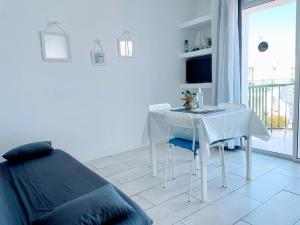 コラレホにあるSinfonia Corralejo iRent Fuerteventuraの白い部屋(テーブル、椅子、ベッド付)