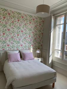 Un dormitorio con una cama con papel pintado floral. en Le Saint-Rémy, en Épernay
