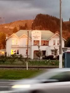 une maison blanche assise sur le côté d'une rue dans l'établissement Manakau House The Old Manakau Hotel 1920, à Manakau