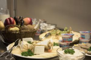 a table with a plate of food and a basket of fruit at Hotel Müritzterrasse in Röbel