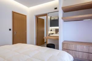 a bedroom with a white bed and a bathroom at Cirillo Family Hotel-Christinas Studios in Mastihari