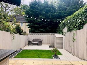 a small garden with a table and a fence at The Villas, Newly refurbished modern home - Free parking, Prime, Netflix in Buckingham