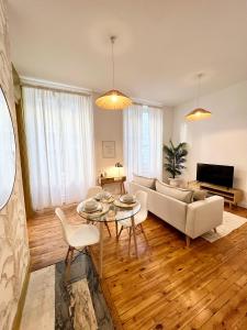 sala de estar con sofá y mesa en La plume dorée - Hotel de ville en Saint Etienne