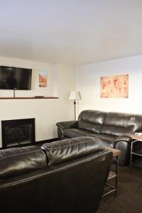 a living room with black leather furniture and a fireplace at Bowen Motel in Moab