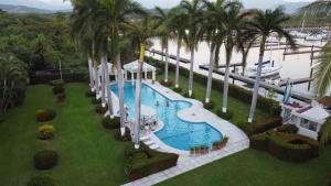 an aerial view of a resort pool with palm trees at Villa KaiKai Marina Ixtapa in Ixtapa