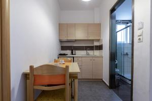 a small kitchen with a wooden table and chairs at Cirillo Family Hotel-Christinas Studios in Mastihari