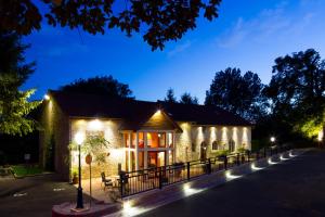 a building with lights on it at night at Logis Hostellerie la Chaumière in Arsonval