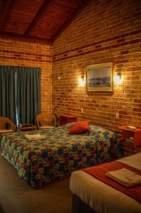 Un pat sau paturi într-o cameră la Beenleigh Village Motel