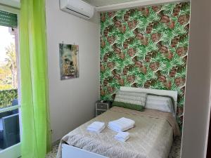 una piccola camera con un letto con una parete verde di B&B Rosy a Napoli