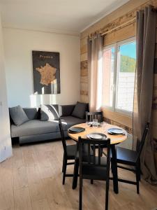 een woonkamer met een tafel en een bank bij Balade en Forêt, 3min du Zoo in Saint-Aignan