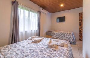 1 dormitorio con 2 camas y ventana grande en Hotel Cabinas el Tecal, en Uvita