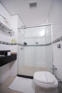 a white bathroom with a shower and a toilet at Metropolitan Hotel in Teresina