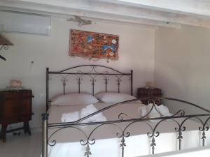 a bedroom with a bed and a picture on the wall at casa vacanza ginevra in Marzamemi