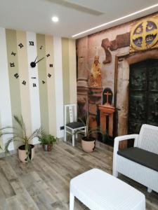uma sala de estar com um relógio na parede em PENSION PORTA SANTA em Baleira