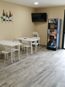 a dining room with tables and a refrigerator at PENSION PORTA SANTA in Baleira