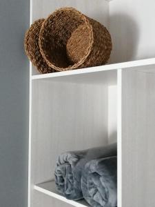 a white shelf with a basket on top of it at PENSION PORTA SANTA in Baleira