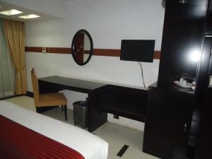 a bedroom with a desk and a bed and a mirror at Sea Princess Hotel in Cox's Bazar