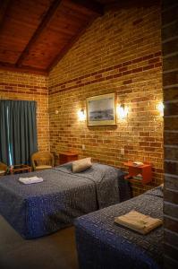 Un pat sau paturi într-o cameră la Beenleigh Village Motel