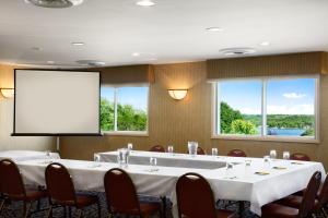 a conference room with a large table and a screen at Super 8 by Wyndham Brockville in Brockville