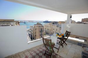 a balcony with a table and chairs and a view of a city at A Babordo B&B in Trapani