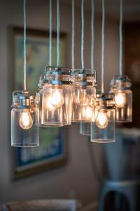 a group of mason jar lights hanging from a ceiling at A Tide that Binds Us in Siesta Key