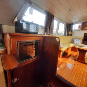 sala de estar con TV en la parte superior de un barco en Bateau le Zimon - logement insolite, en Rouen