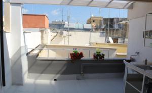Blick auf einen Balkon mit zwei Pflanzen auf einem Felsvorsprung in der Unterkunft Aura b&b in Bari