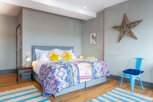 a bedroom with a bed and a blue chair at Sailors Rest in Appledore