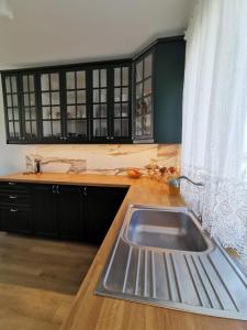 a kitchen with a sink and black cabinets and a window at Milusi Domek in Łagów