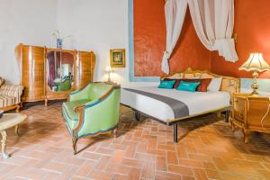 a bedroom with a bed and a couch and a chair at Ayenda Meson de San Sebastian in Puebla