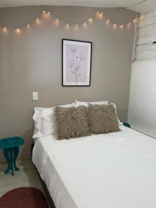 1 dormitorio con 1 cama blanca con luces en la pared en Cabañas Valle del Cocora La Truchera en Salento