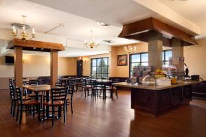 un restaurante con mesas y sillas en una habitación en Super 8 by Wyndham Brockville, en Brockville