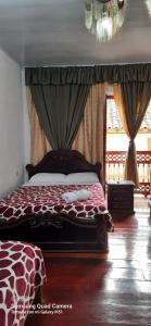 1 dormitorio con cama de jirafa y lámpara de araña en Bonsai Hotel Salamina Caldas, en Salamina