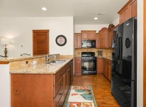 cocina con armarios de madera y nevera negra en Charming Downtown Home, en Coeur d'Alene