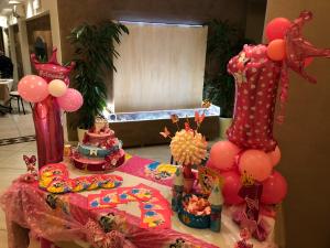 a table with a pink birthday party with cakes and balloons at DonnaRosaHOME in Oliveri