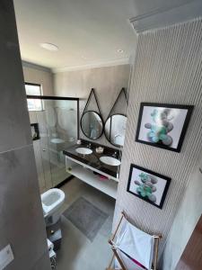 La salle de bains est pourvue de 2 lavabos et d'un miroir. dans l'établissement 5 suítes Búzios frente Mar ! Piscina , casa NOVA, à Búzios