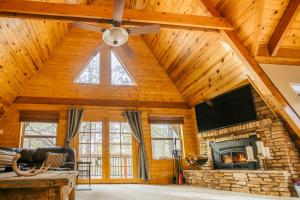 a living room with a ceiling fan and a fireplace at Furnished Deck + Fire Pit: Happy Jack Cabin in Happy Jack