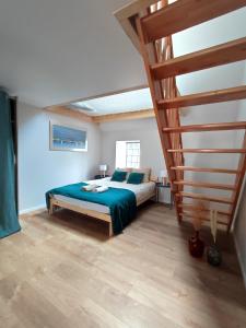 a bedroom with a bed and a spiral staircase at Le filet Cherbourgeois in Cherbourg en Cotentin